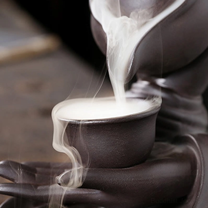 Detailed close-up of backflow incense cone and smoke cup showing thick white smoke cascade effect