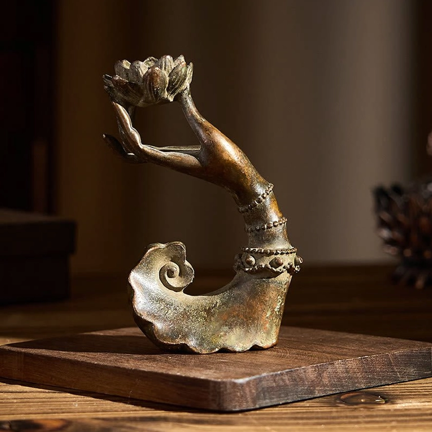 Buddha's hand lotus bronze statue displayed on wooden square platform - warm wooden setting for home meditation altar