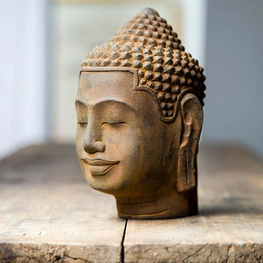 Side profile close-up of Buddha head statue showing ear and contemplative closed-eye facial expression