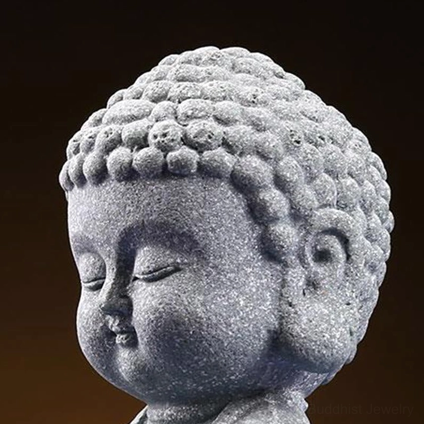 Extreme close-up of Buddha head statue showing delicate curly hair and closed peaceful eyes with soft facial features