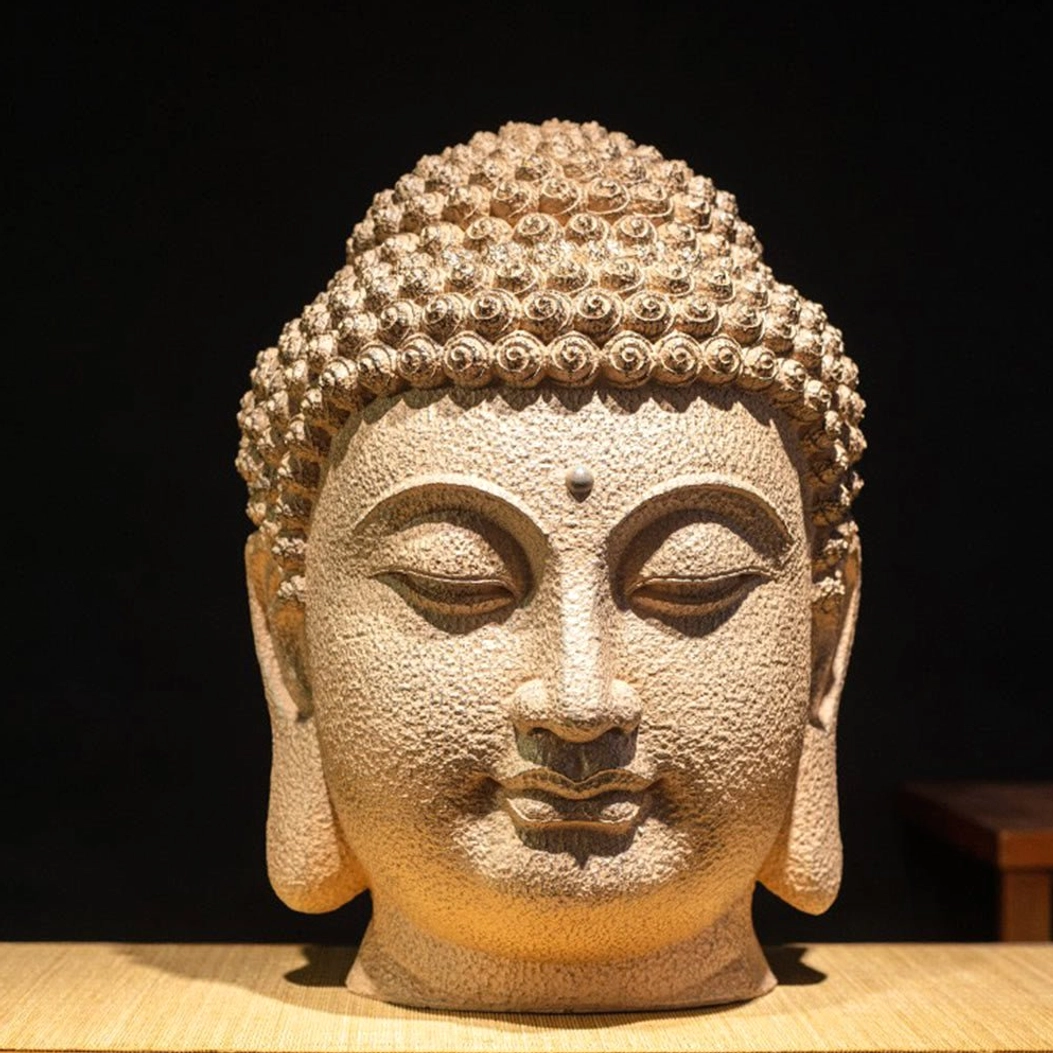 Front facing meditating Buddha head statue with symmetrical closed-eye design and ushnisha topknot carved in premium resin