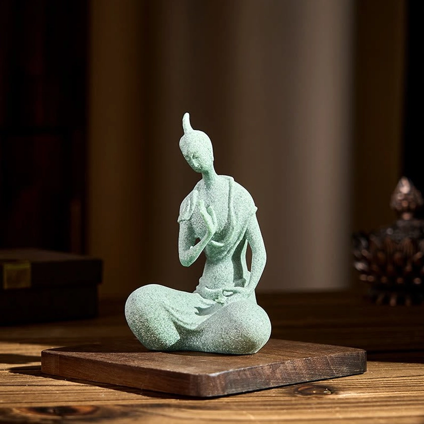 Seated Buddha ornament placed on wooden table with traditional screen backdrop, showcasing authentic home décor styling
