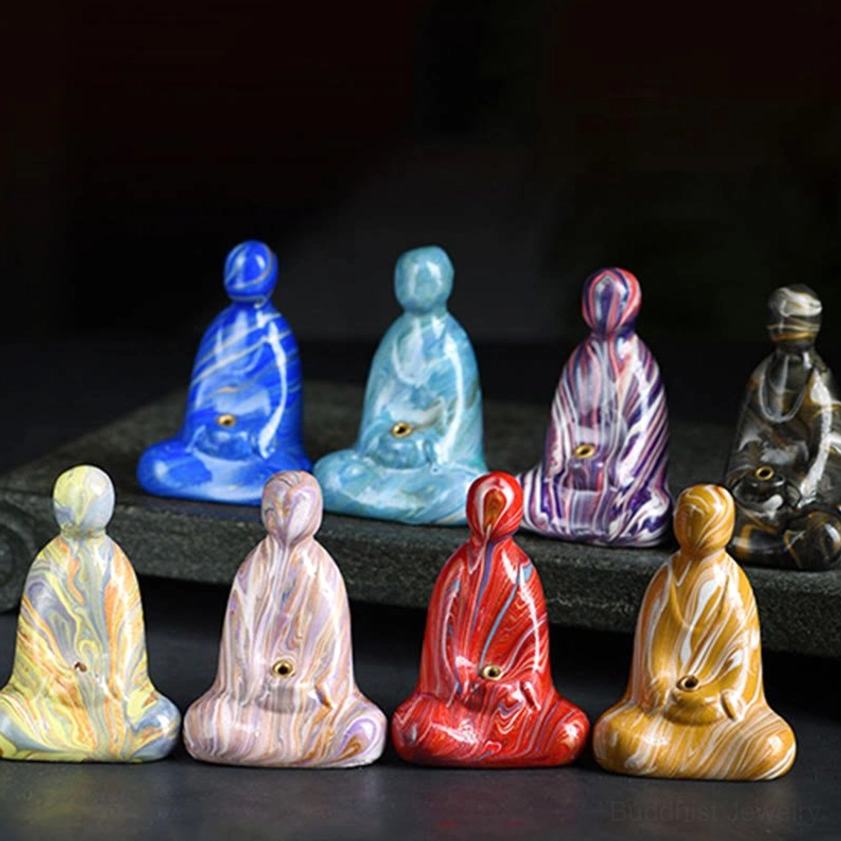 Collection of Buddha incense holders in multiple marbled color options displayed on dark surface