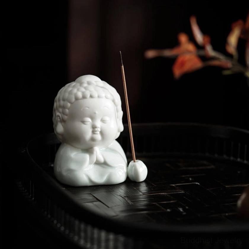 Overhead Buddha incense holder with burning incense stick displayed on black tray with matching ceramic base - spiritual setup
