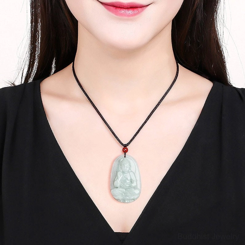 Buddha jade necklace worn on model with red beads on black cord, close-up lifestyle shot
