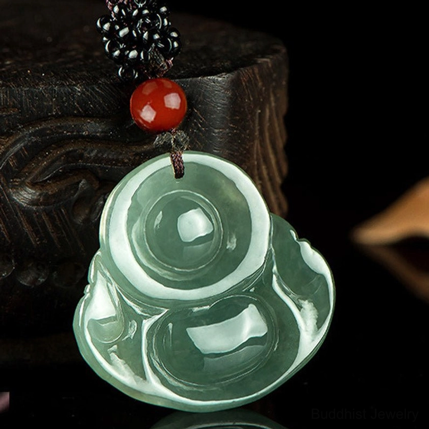 Back view of Laughing Buddha jade pendant showing traditional ingot pattern embossed on reverse side, symbol of wealth and prosperity