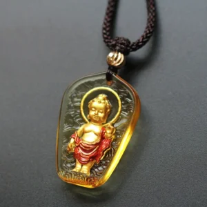 Tibetan Buddha Liuli crystal pendant with gilded halo detail - handcrafted trapezoidal design featuring embossed Buddha figure with cloud patterns