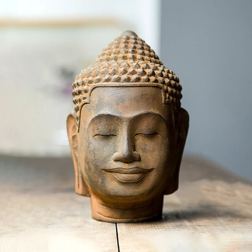 Meditating Buddha head statue positioned in meditative home altar setting, promoting mindfulness and inner peace