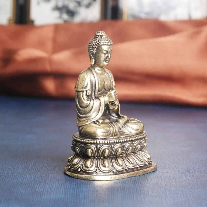Buddha altar statue side profile, showing detailed robes and ritual hand mudra gesture, lotus pedestal base