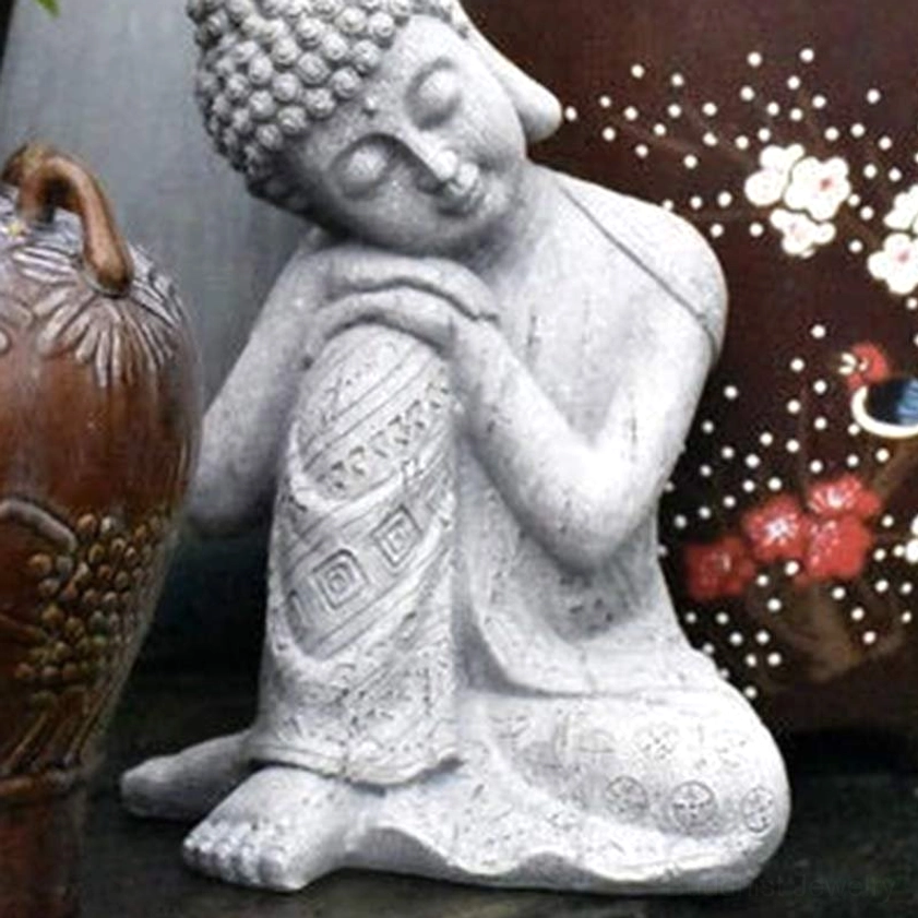 Matte grey resin Buddha statue in peaceful meditation posture displayed with decorative ceramic vase