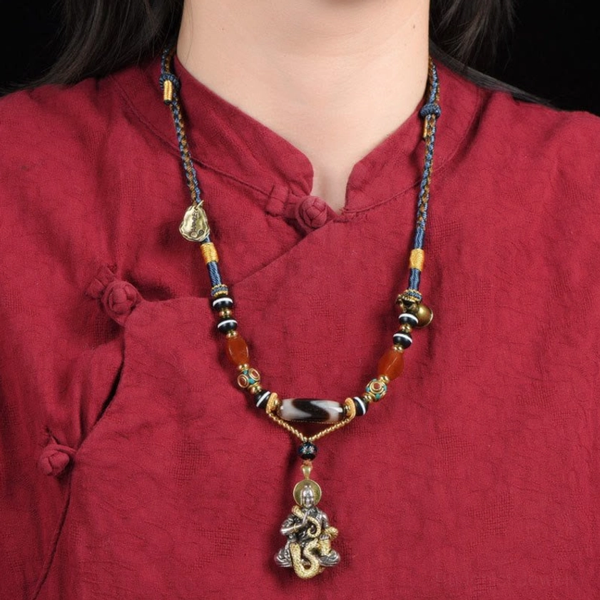 Woman wearing snake Buddha dzi bead necklace at collarbone, styled with traditional red clothing