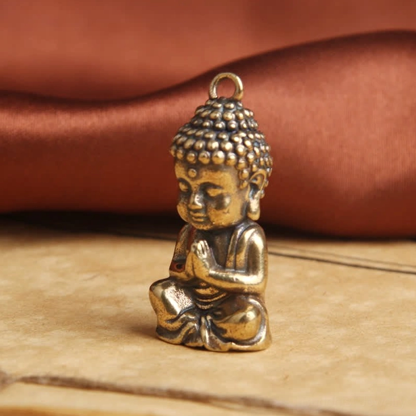 Left side profile of Buddha copper pendant showing seated posture with detailed hair bun and spiritual expression