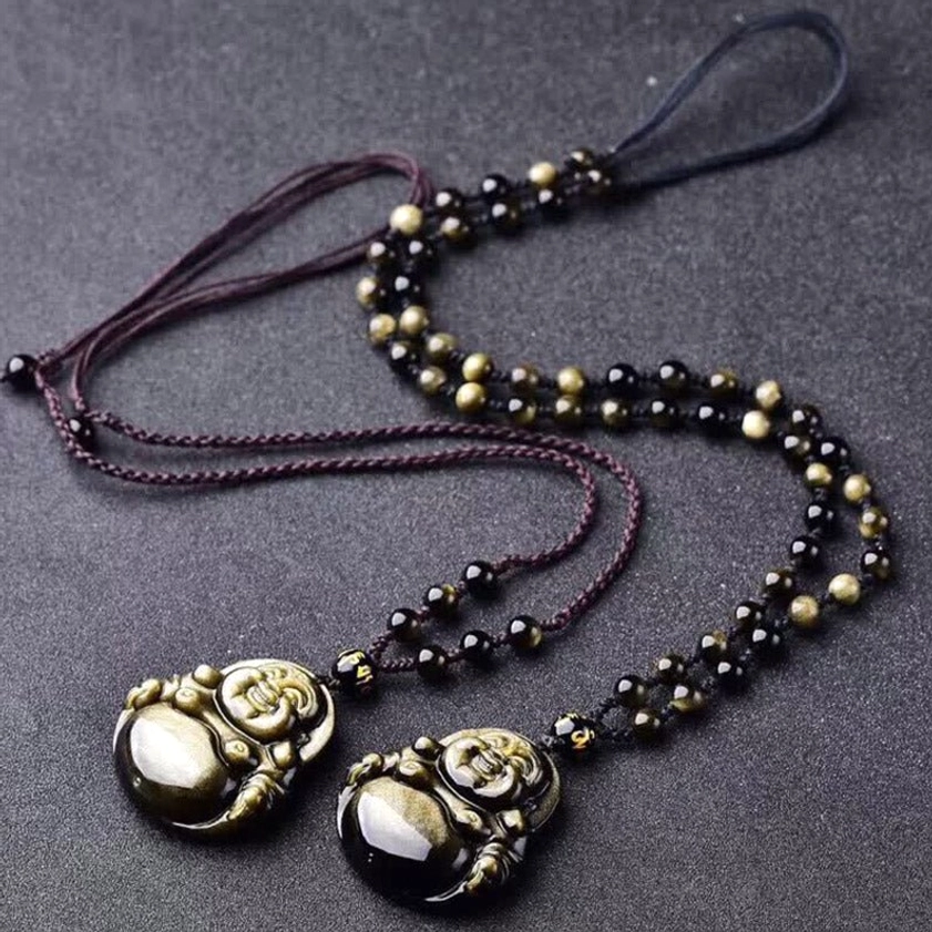 Two adjustable Buddha pendant necklaces with wax cord and mixed black obsidian beads on dark studio backdrop