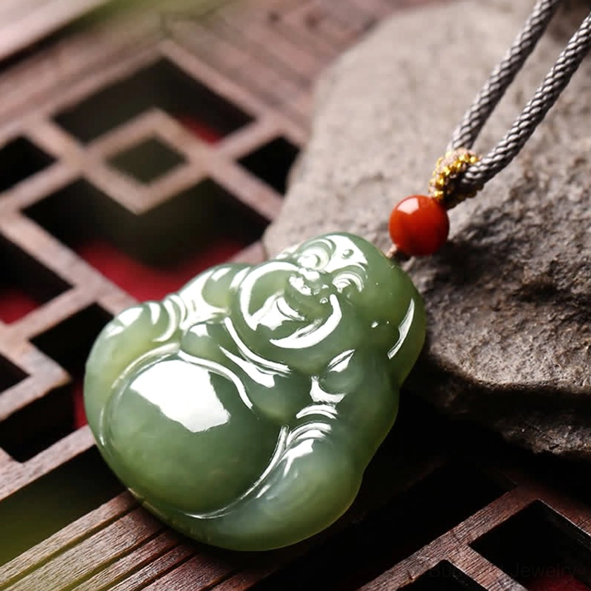 Maitreya Buddha pendant side profile view showing carved details and jade thickness on stone background