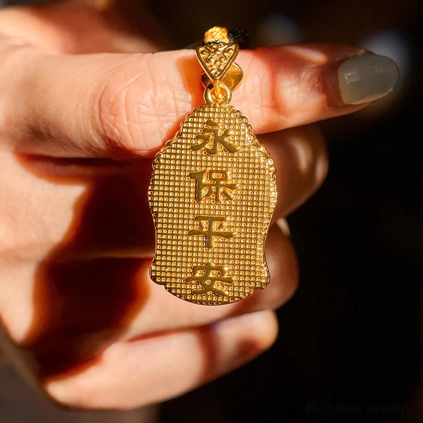 Buddha pendant close-up showing engraved Chinese blessing text on back