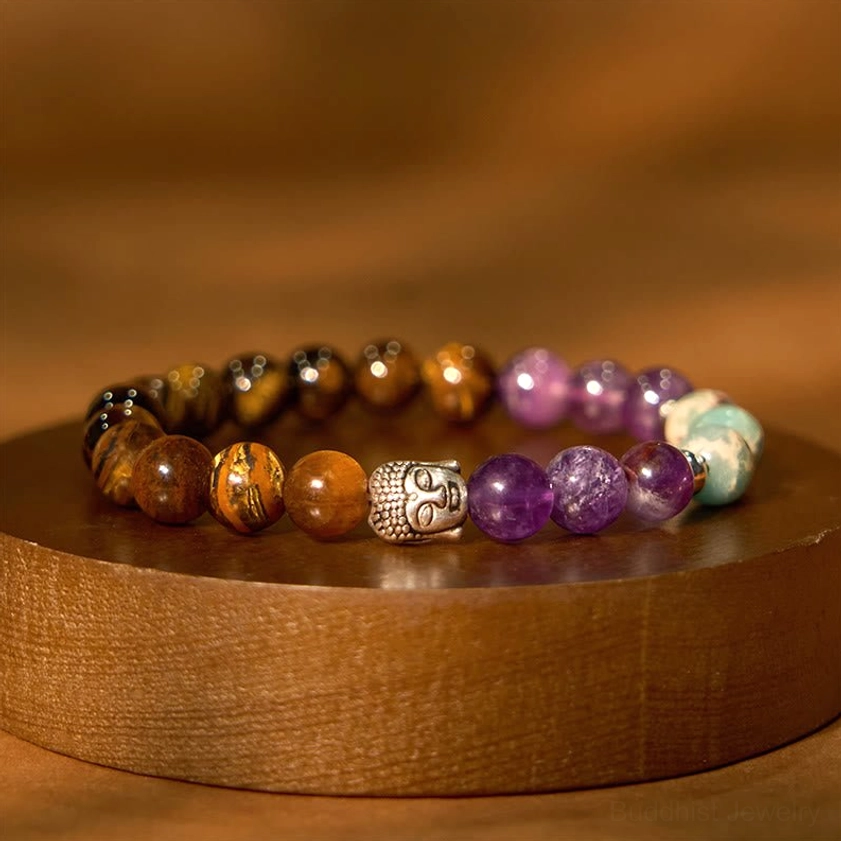 Natural gemstone Buddha bracelet displayed on round wooden tray with protective energy stones