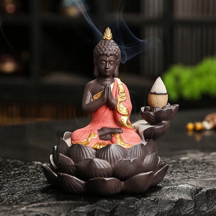 Red ceramic Buddha incense burner with prayer blessing hands mudra, hand-painted robe detail on dark background