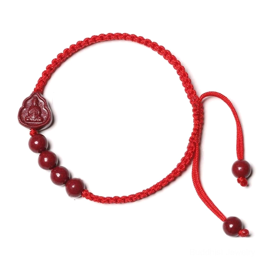 Side view of red string Buddhist bracelet with cinnabar beads and Buddha charm, showing pull-adjustable cord design