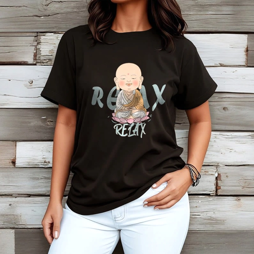 Woman wearing black Buddhist meditation tee with white jeans, wooden plank wall backdrop for everyday style