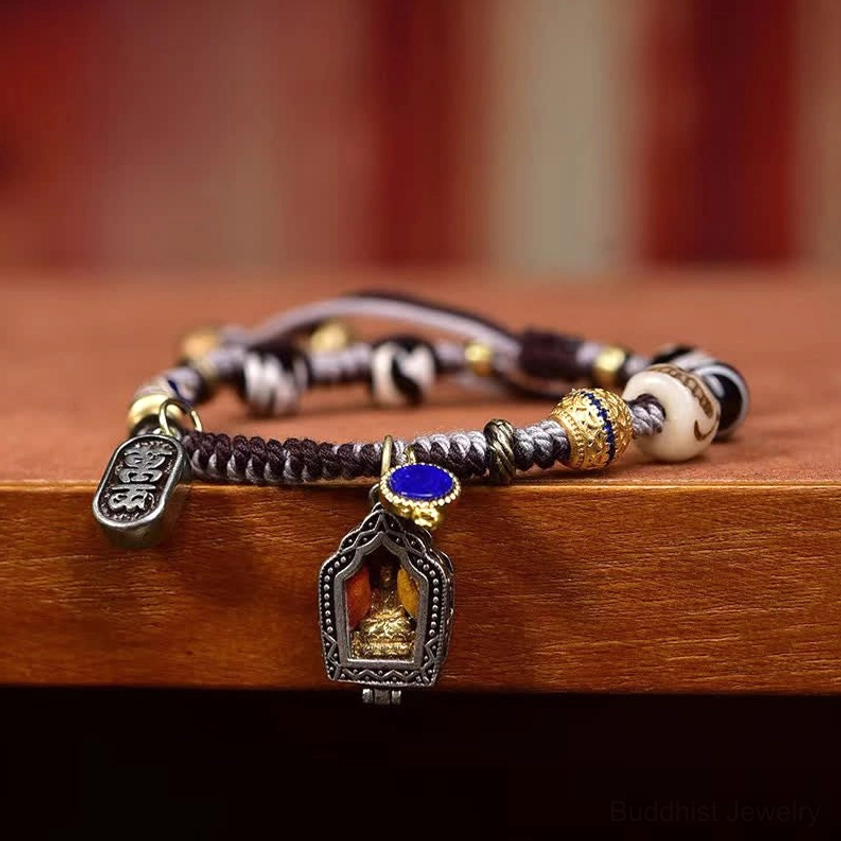 Side view of copper Buddha compassion bracelet on red background showcasing metal beads and dual signature Buddha charms