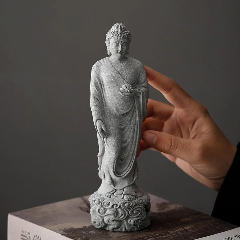 Handcrafted Buddha statue on book with hand interaction showing matte texture detail
