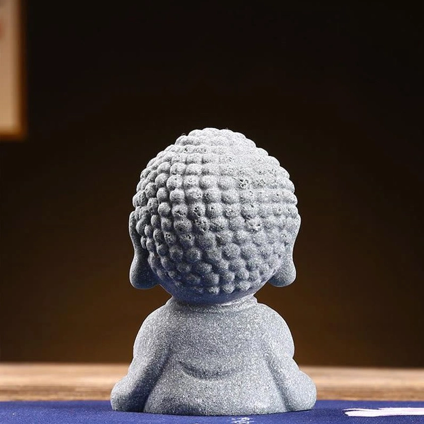 Rear view of handcrafted baby Buddha statue showing detailed curly hair texture and natural sandstone material