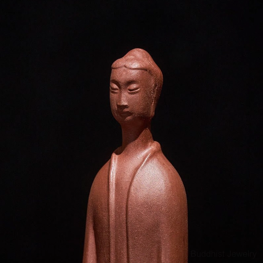 Close-up detail of Buddha statue face showing fine robe design and peaceful expression