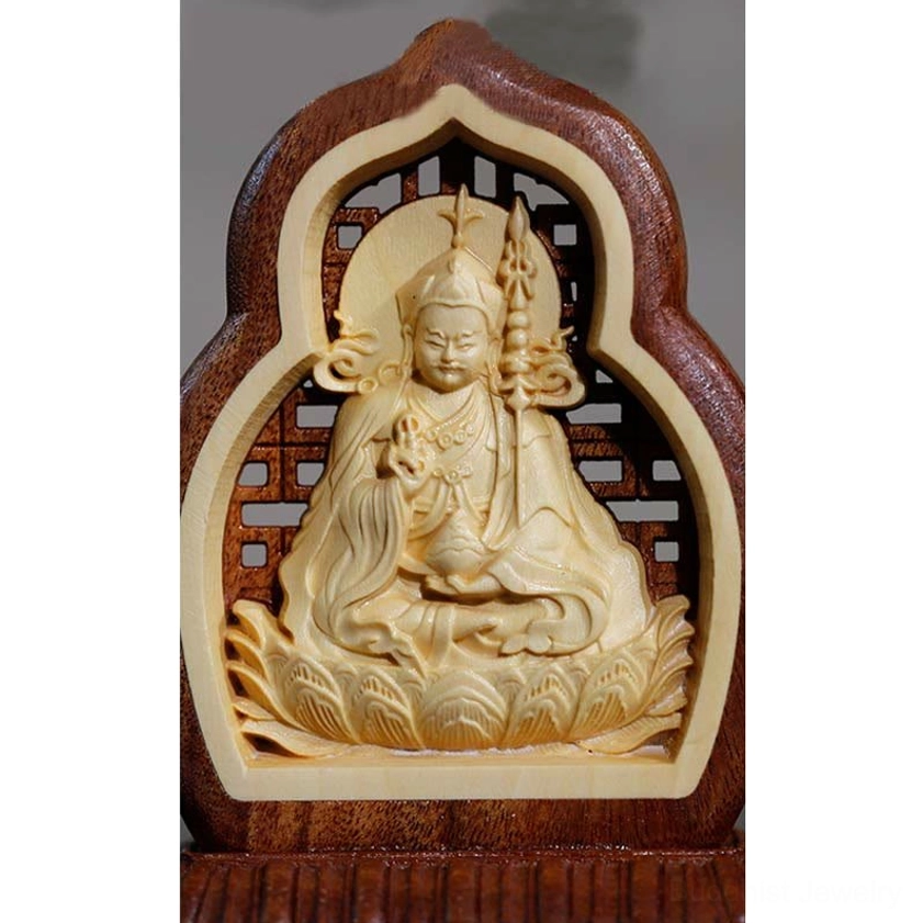 Close-up magnified front view of Buddha statue showing detailed carving of Buddha's staff, lotus seat and hollowed frame