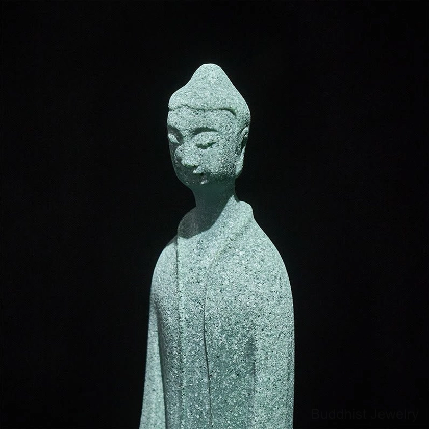 Close-up upper body and serene face of Buddha statue displaying peaceful meditation expression and matte sandstone texture