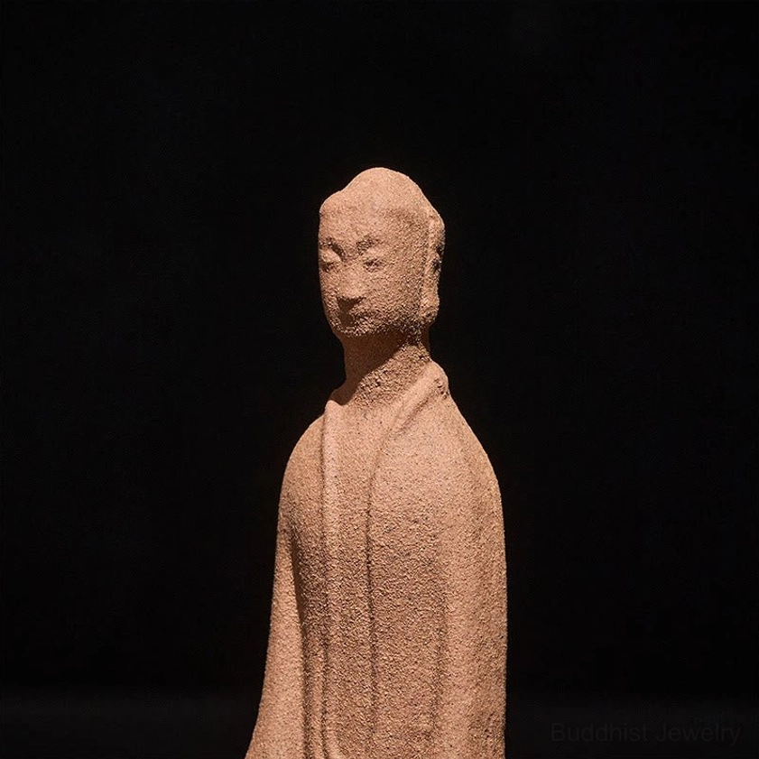 Close-up of ceramic Buddha statue showing fine facial features and meditative expression, matte sand-textured details