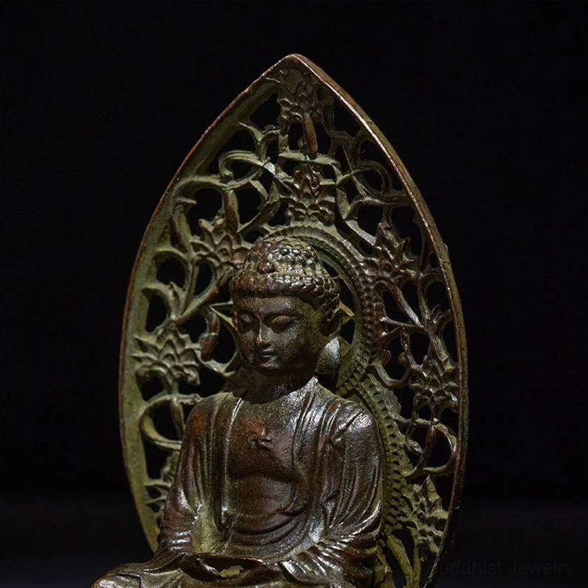 Close-up of Buddha statue face and upper body showing detailed carved facial features and weathered patina