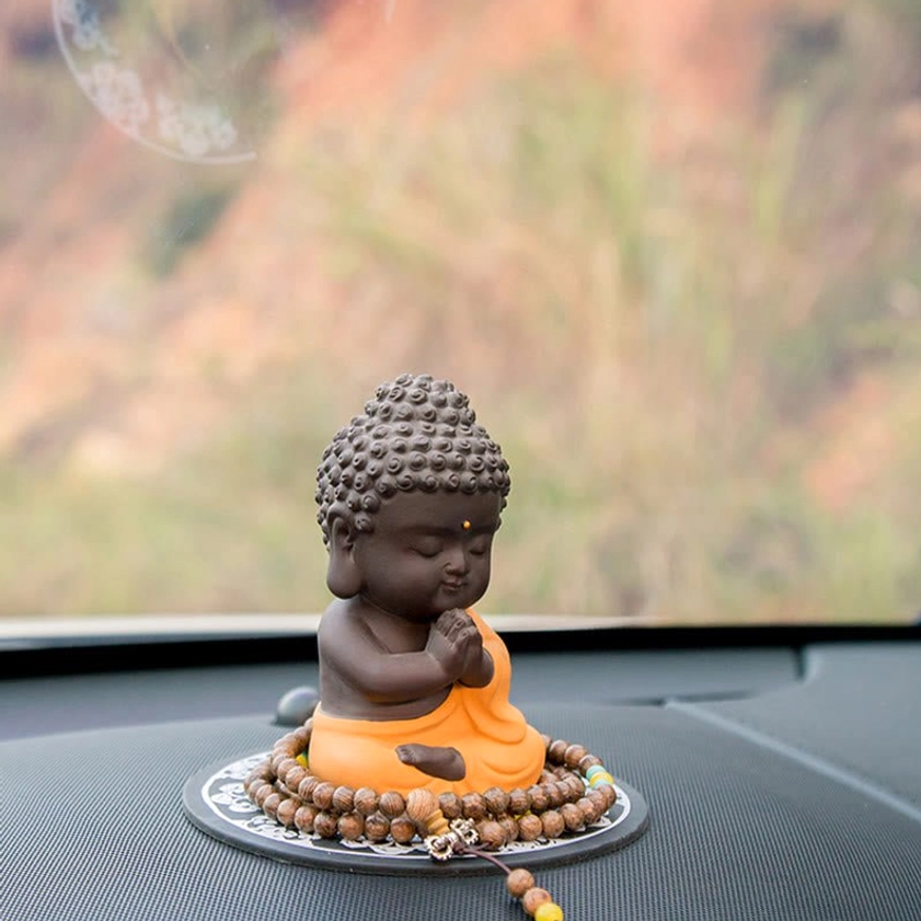Handcrafted Buddha figurine detail shot, showing fine artisanal work and natural purple clay material properties and color