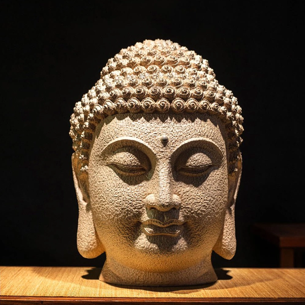 Close-up frontal view of meditating Buddha head showing intricate facial carving and serene closed-eye expression