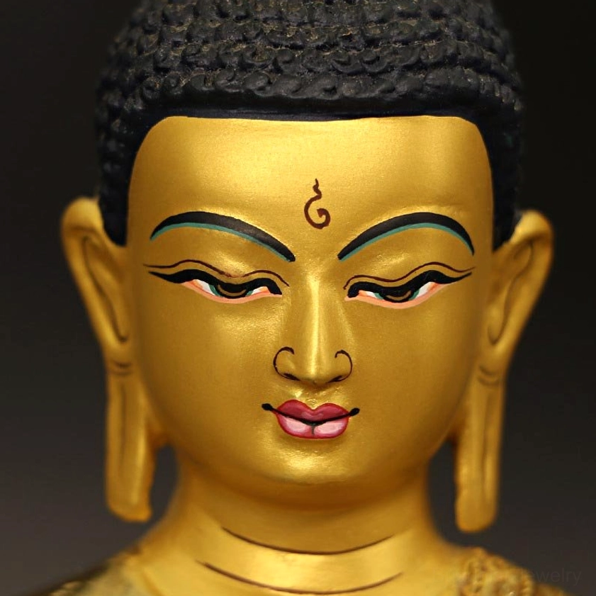 Handcrafted Buddhist Buddha statue detail shot showing gold-plated facial features and serene spiritual expression