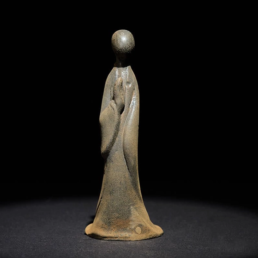 Front view of handcrafted standing Buddha meditation statue with folded prayer hands and serene formless design