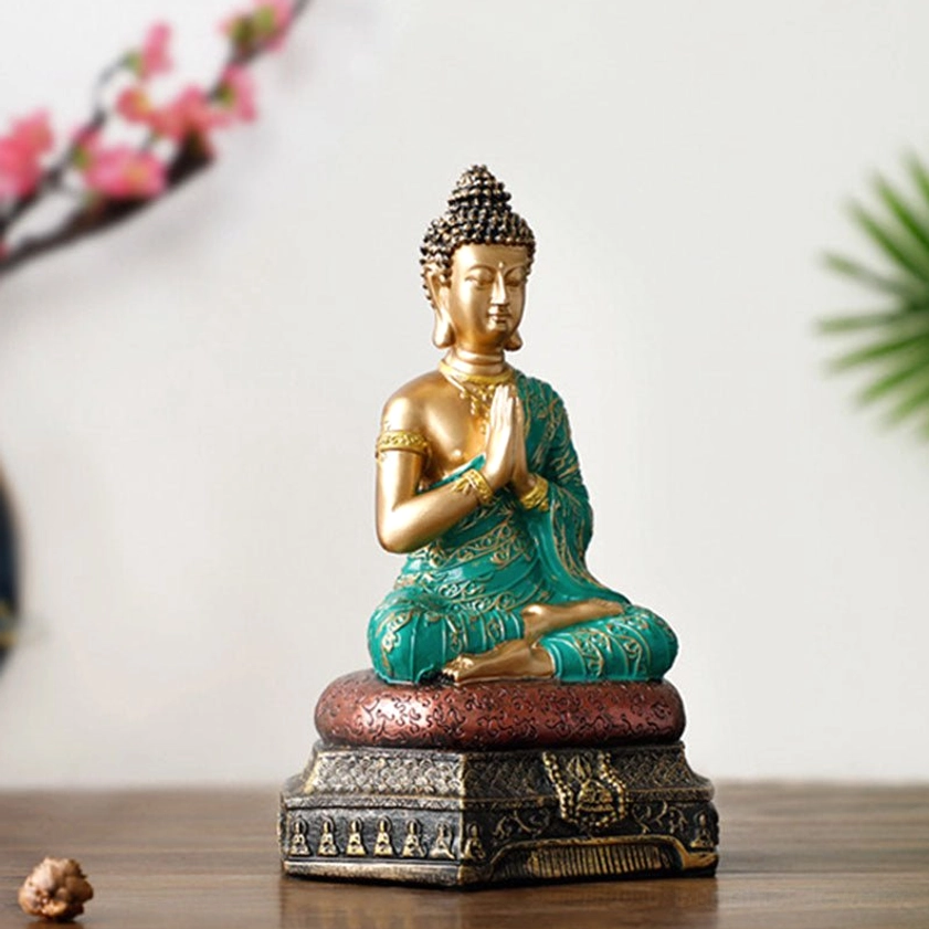 Golden Buddha ornament with detailed arm accessories and peaceful sitting posture on wooden display