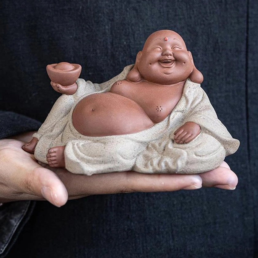 Laughing Buddha statue detail showing ingot, abundance symbol, handmade purple clay, spiritual home décor art piece
