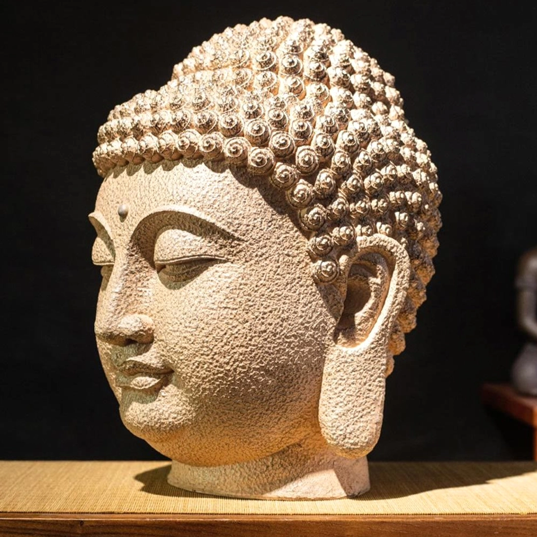 Left side view of meditating Buddha resin head showing elongated earlobes and detailed hair bun carving