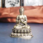 Handcrafted brass Buddha meditation statue front view, seated in lotus position with ornate carved base, antique copper finish
