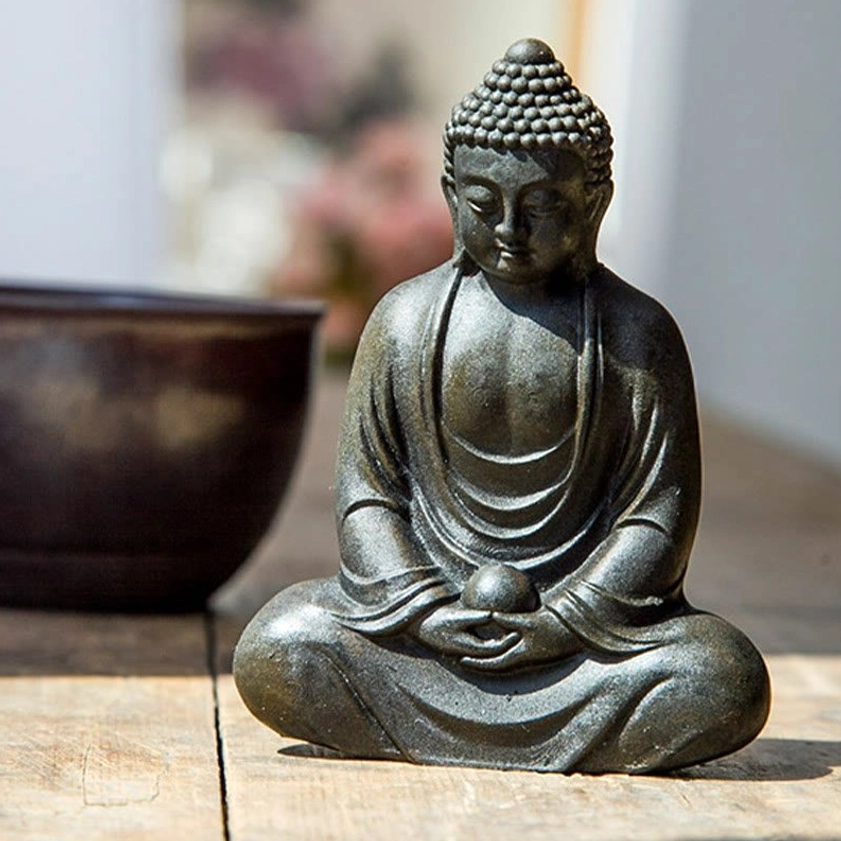 Meditating Buddha statue detail showing meditation mudra hand gesture and serene facial expression