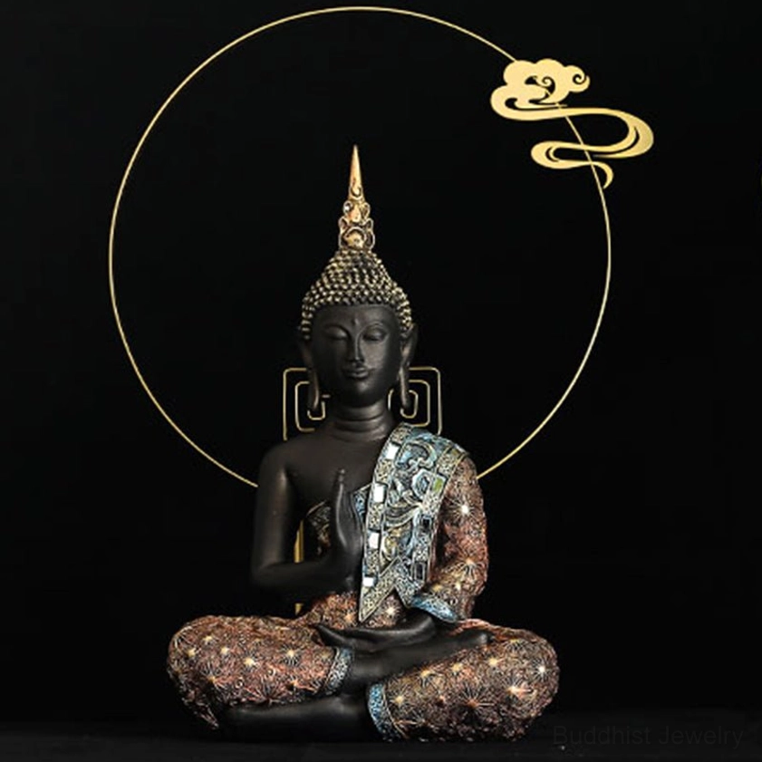 Buddha statue with black resin body and blue-brown embroidered robe seated in meditation pose with decorative circular frame background