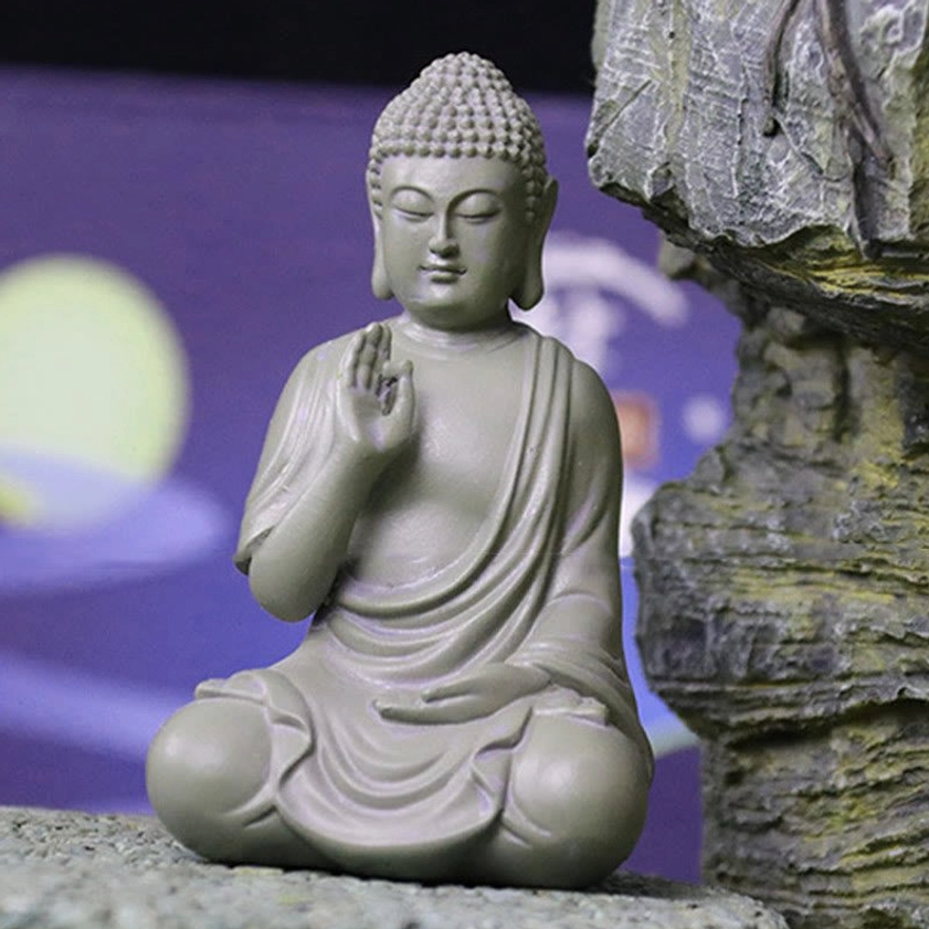 Serenity Buddha desk decoration with closed eyes and peaceful expression, front three-quarter angle against purple night background
