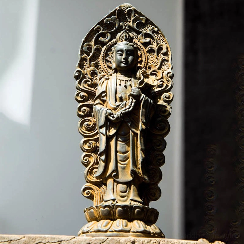 Close-up bodhisattva resin statue detail shot showing prayer beads and intricate Buddhist robe designs on handcrafted iron powder sculpture with spiritual symbolism