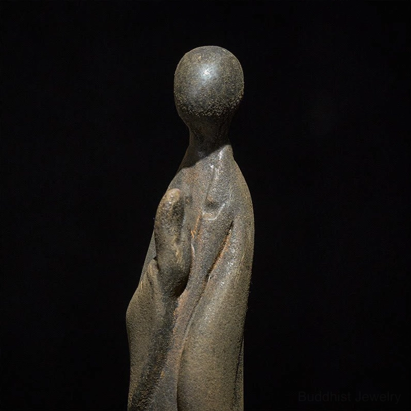 Close-up detail of Buddha statue showing intricate prayer hands mudra position and textured iron powder resin surface