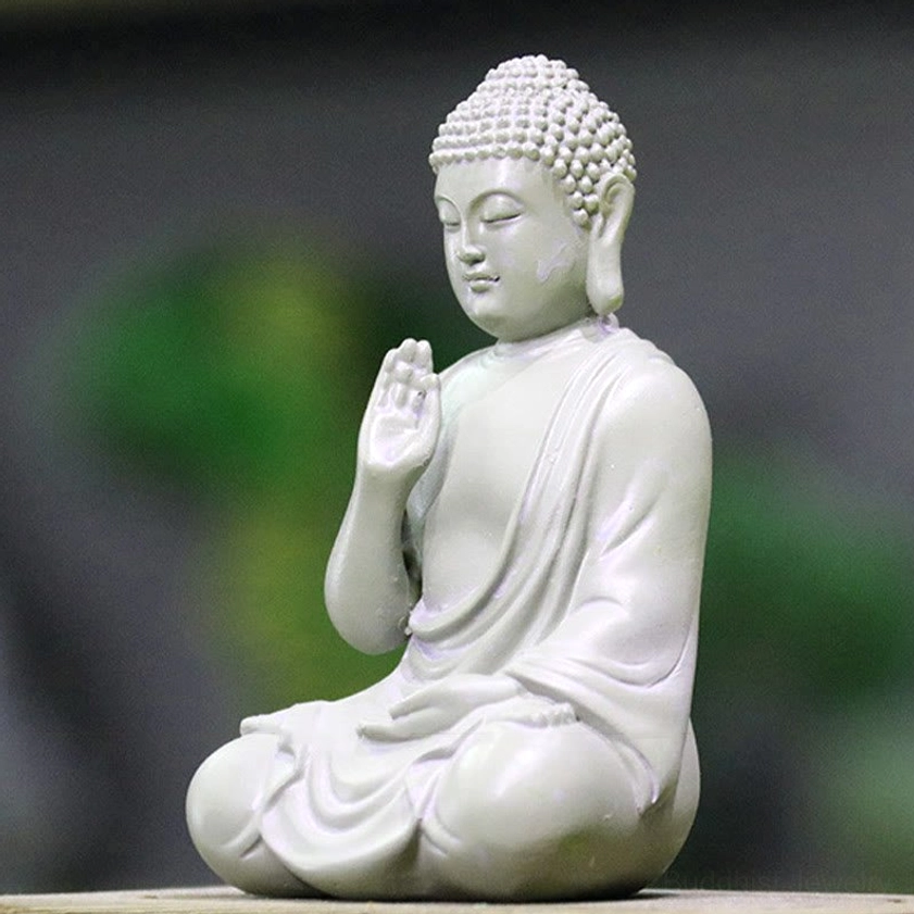 Left side profile of small Buddha home decoration statue showing elongated earlobes symbolizing wisdom and calm serene face