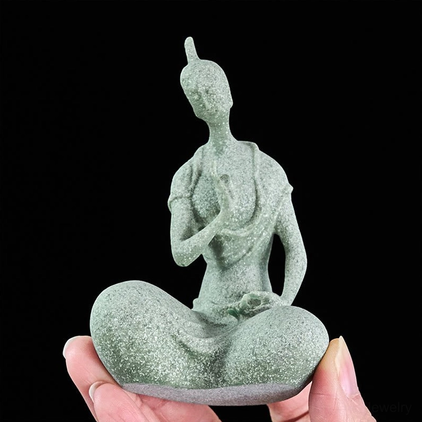 Buddha figurine rear view showing back details, robe folds, and traditional topknot, dark studio background