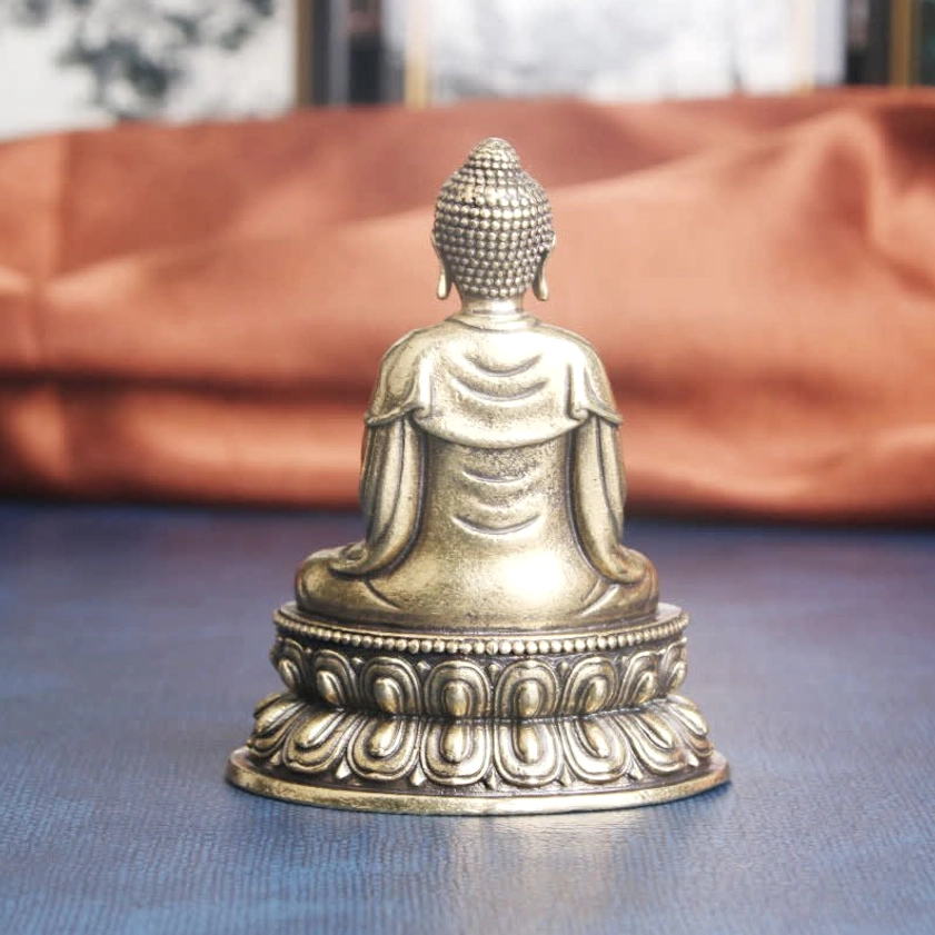 Back view of handmade Buddha statue, showing Buddhist robe folds and lotus pedestal base structure