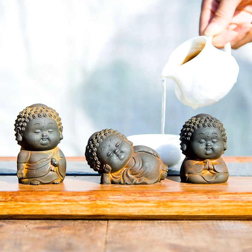 Buddha statue collection arranged on decorative tea tray showing different meditative poses and hand gestures