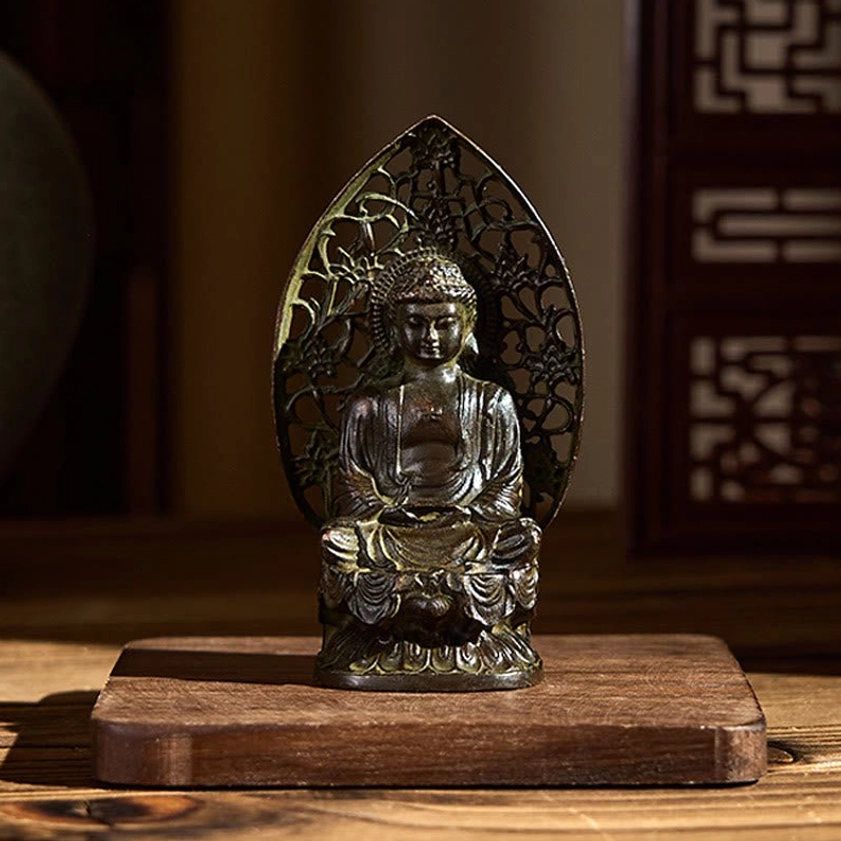 Buddha statue three-quarter angle displayed on wooden meditation base showing intricate carved details