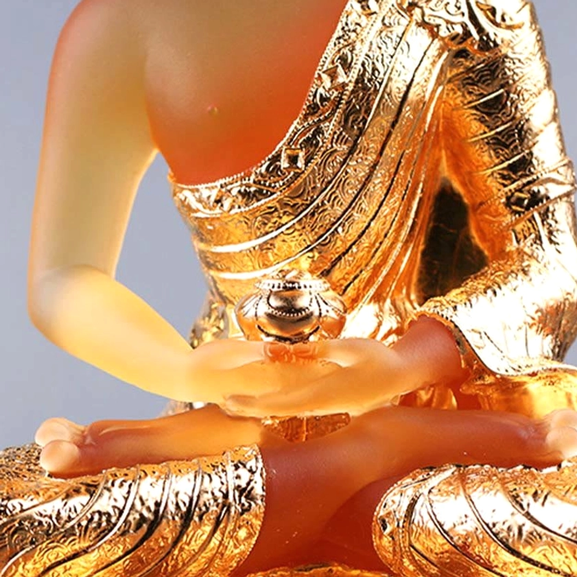 Upper body close-up of Liuli glass Buddha showing ritual bowl in palms and intricately textured gold plated robe